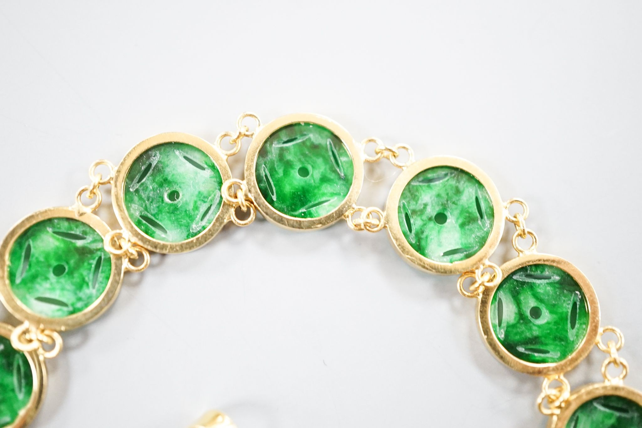 A Chinese 850 yellow metal and jade disc bracelet, 15cm and a matching small pendant, gross 9.7 grams.